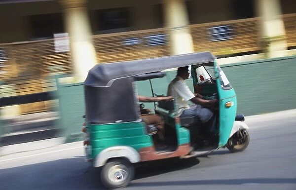 Tuk tuk driving along street, Negombo, Western Province, Sri Lanka, Asia