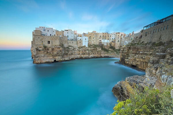 Turquoise sea at sunset framed by the old town perched on the rocks, Polignano a Mare