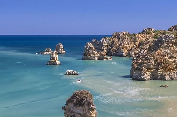 The turquoise water of the Atlantic Ocean and cliffs surrounding Praia Dona Ana beach