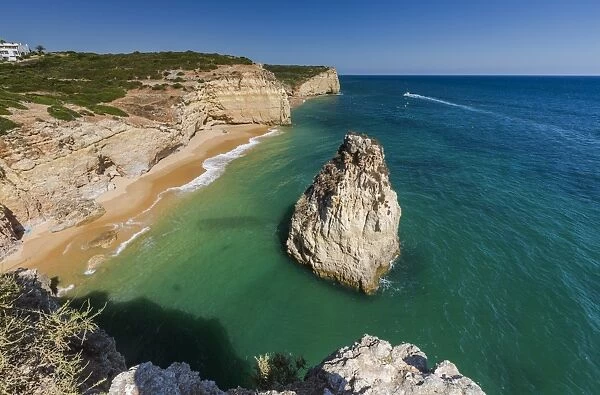 The turquoise waters of the ocean frames the sandy beach of Praia do Torrado, Algarve