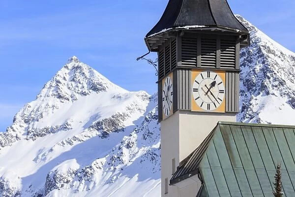 The typical alpine bell tower frames the snowy peaks, Langwies, district of Plessur