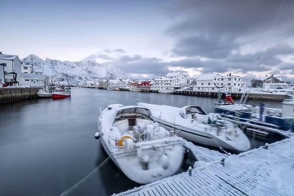 The typical fishing village of Henningsvaer surrounded by snow capped mountains and the cold sea