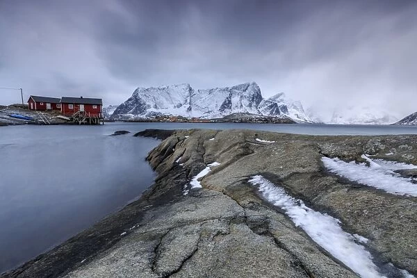 Typical landscape of Hamnoy with red houses of fishermen and the snowy mountains