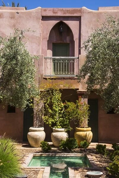 Typical Moroccan architecture, riad adobe walls, fountain and flower pots, Morocco