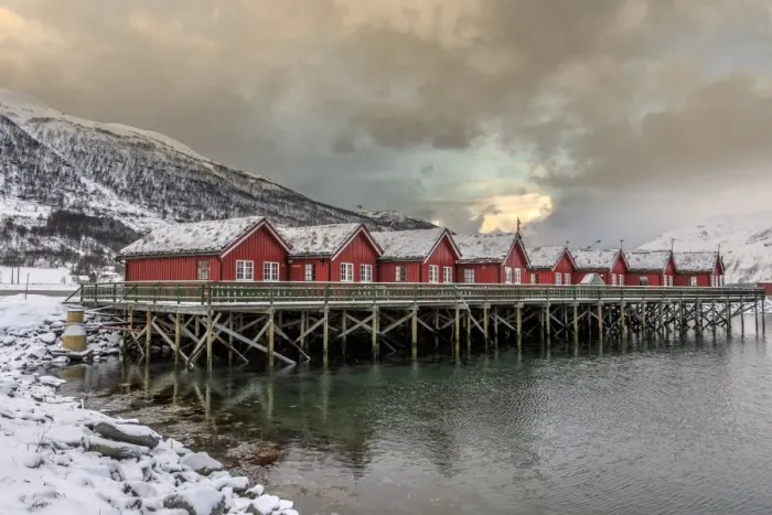 Framed Print : Typical red wooden huts of fishermen in the snowy and icy landscape of Lyngen Alps Framed Print : Typical red wooden huts of fishermen in the snowy and icy landscape of Lyngen Alps