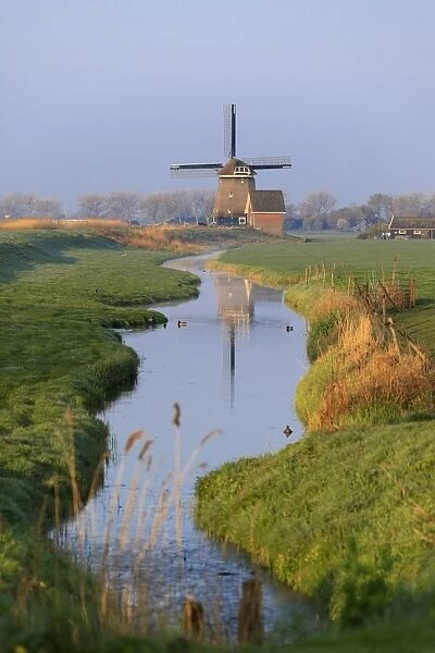 Typical windmill reflected in the canal at dawn, Berkmeer, municipality of Koggenland