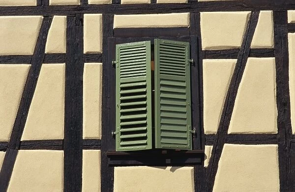 Detail of typical window with green shutters in timbered house in the old town of Ribeauville