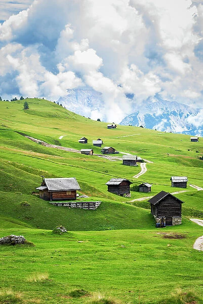 Typical wooden mountain huts on green fields, Sass de Putia, Dolomites, Passo delle Erbe, South Tyrol, Italy, Europe