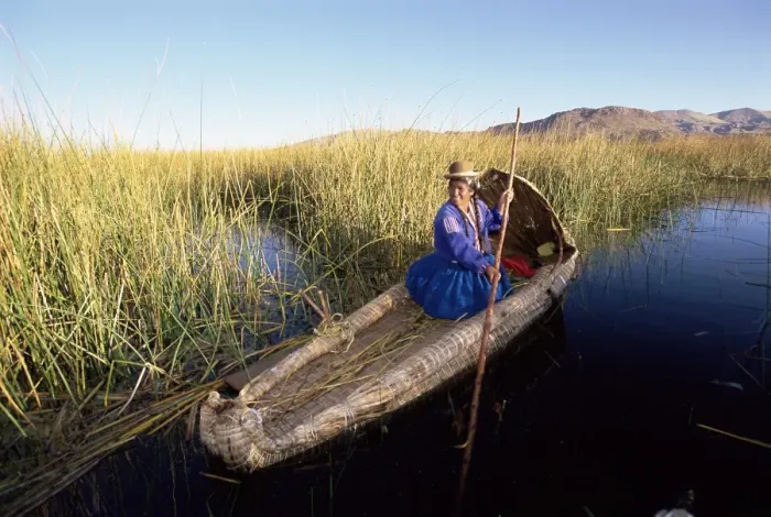 Framed Print : A Uros Indian woman in a traditional reed boat