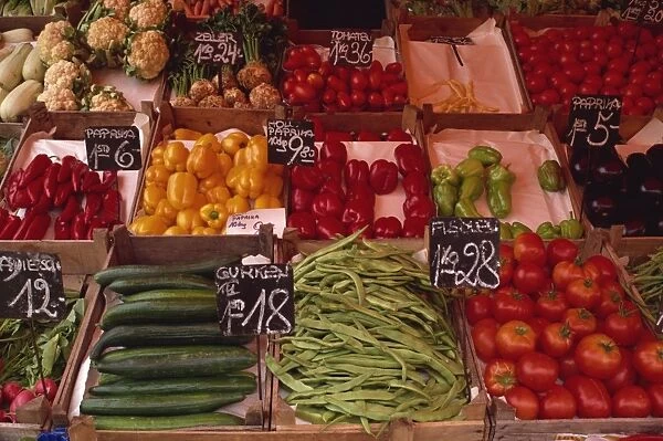Vegetables including beans, cucumbers and peppers, in wooden boxes in the market in Vienna