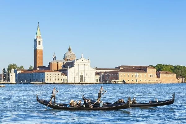 Venetian gondolas with tourists opposite the Island of San Giorgio Maggiore, on the
