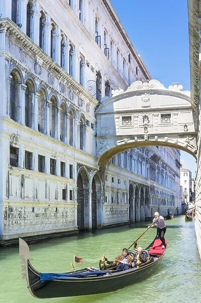 Venice Gondola with tourists going under the Bridge of Sighs (Ponte dei Sospiri)