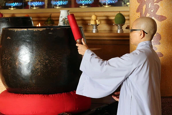 Vietnamese Buddhist nun using a giant singing bowl, Vung Tau, Vietnam, Indochina