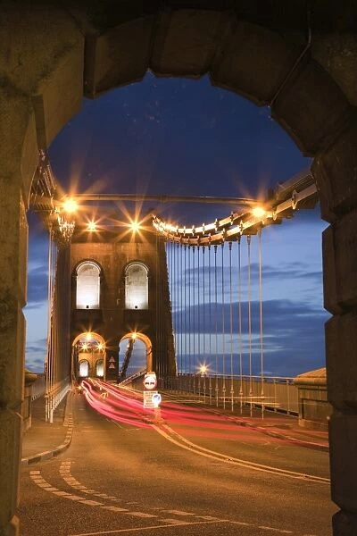 View along the A5 road at night across the Menai suspension bridge, built by Thomas Telford in 1825