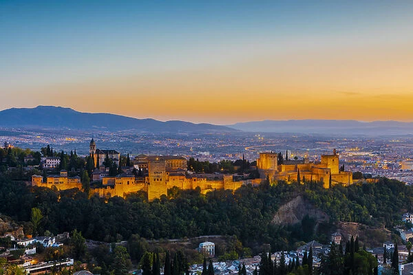 View of Alhambra, UNESCO World Heritage Site, and Sierra Nevada mountains at dusk
