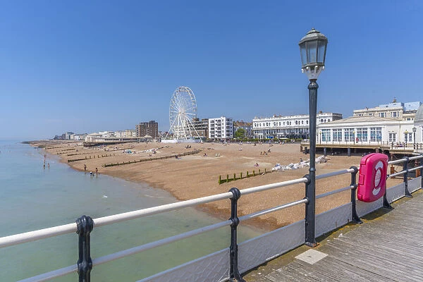View of beach front houses and ferris wheel from the pier, Worthing, West Sussex, England