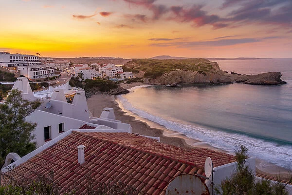 View of beach and rooftops at sunset in Arenal d en Castell, Es Mercadal, Menorca, Balearic Islands, Spain, Mediterranean, Europe