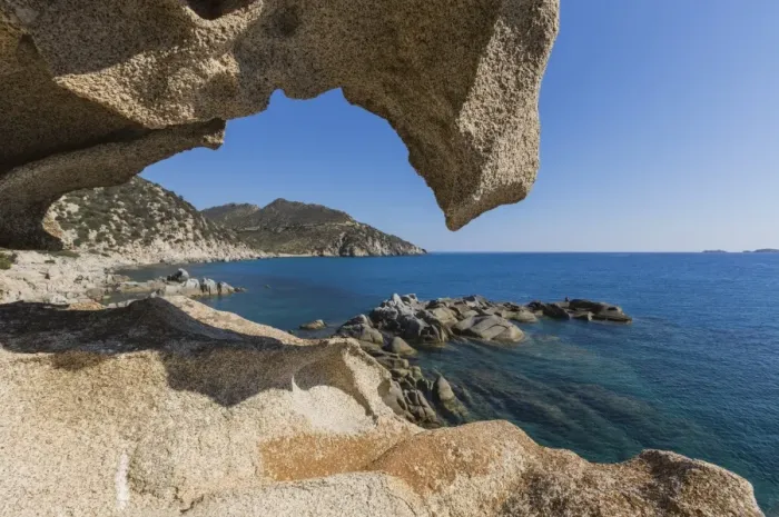 Framed Print : View of the blue sea from a natural sea cave of rocks shaped by wind, Punta Molentis