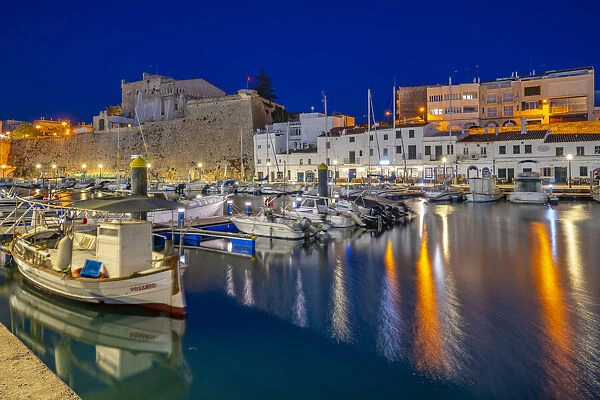 View of boats in marina overlooked by whitewashed buildings at dusk, Ciutadella, Menorca, Balearic Islands, Spain, Mediterranean, Europe