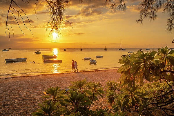 View of boats and people on Mon Choisy Public Beach at sunset, Mauritius, Indian Ocean, Africa