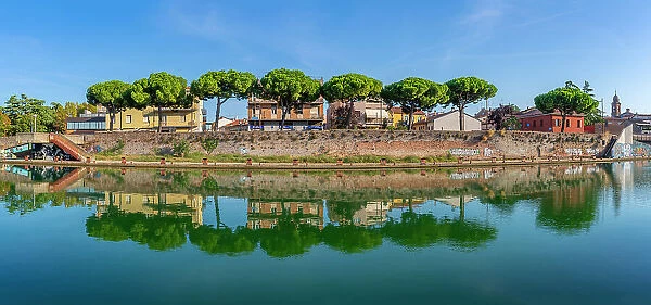 View of buildings and pine trees reflecting on the Rimini Canal, Rimini, Emilia-Romagna, Italy, Europe
