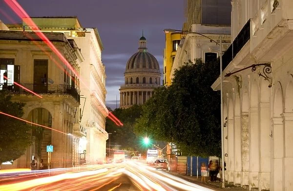 View towards the Capitolio at dusk with light trails of traffic on a busy street