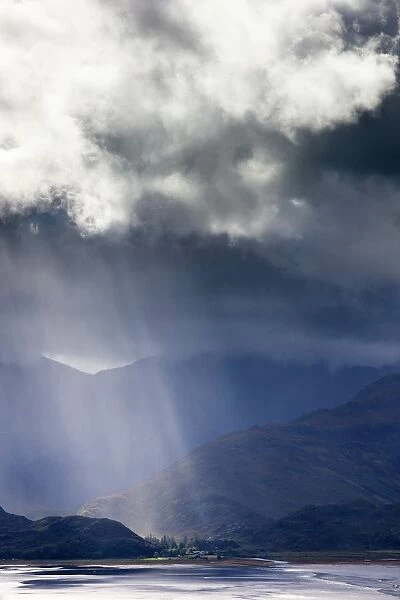 View from Carr Brae towards head of Loch Duich and Five Sisters of Kintail with sunlight bursting through sky, Highlands, Scotland, United