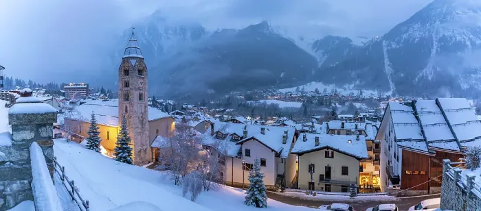 Framed Print : View of Church of Saint Pantalon and the snow covered town centre and mountainous background in winter, Courmayeur, Aosta Valley, Italy