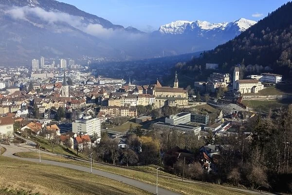 View of the city of Chur surrounded by woods and snowy peaks, district of Plessur