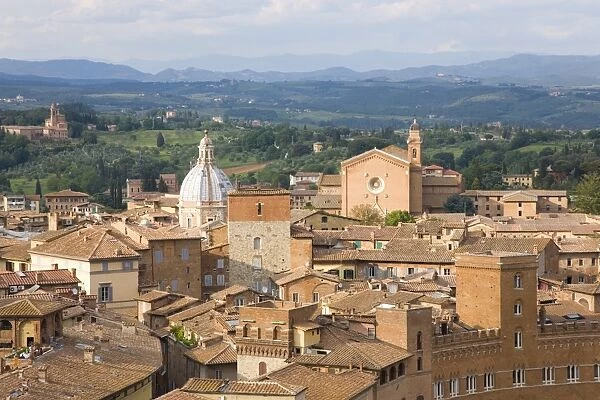 View over city rooftops to rolling hills, the Basilica of San Francesco prominent, UNESCO World Heritage Site, Siena, Tuscany, Italy, Europe