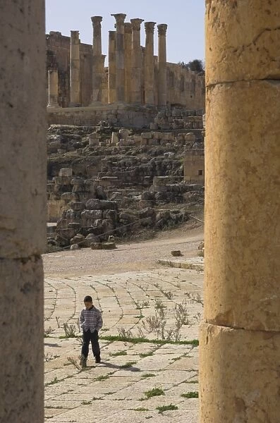 View through columns of boy walking past