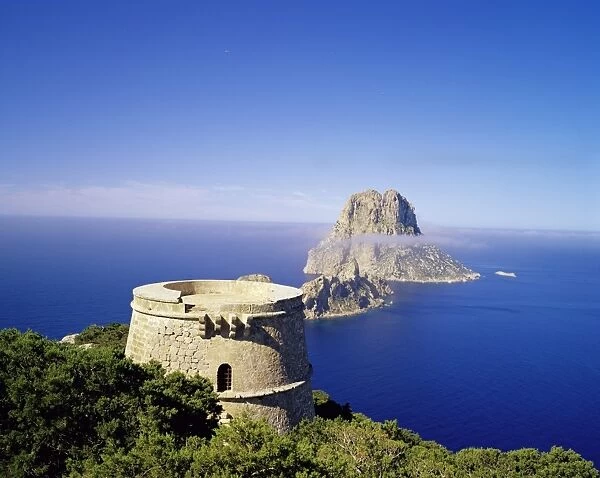 View of defence tower and the rocky island of Es Vedra