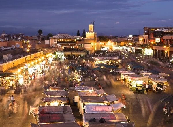 View over Djemaa el Fna at dusk with foodstalls and crowds of people, Marrakech