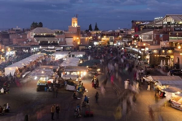 View over the Djemaa el Fna at dusk showing food stalls and crowds of people, Marrakech