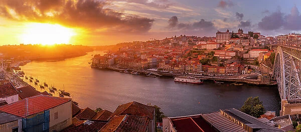 View of the Dom Luis I bridge over Douro River aligned with colourful buildings at sunset, UNESCO World Heritage Site, Porto, Norte, Portugal, Europe