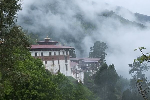 View of the Dzong with hills and fog, Trongsa, Bhutan, Asia