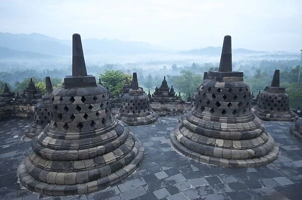 View over early morning monsoon mist lying across countryside, Borobudur Buddhist Temple, UNESCO World Heritage Site, Java, Indonesia, Southeast Asia, Asia
