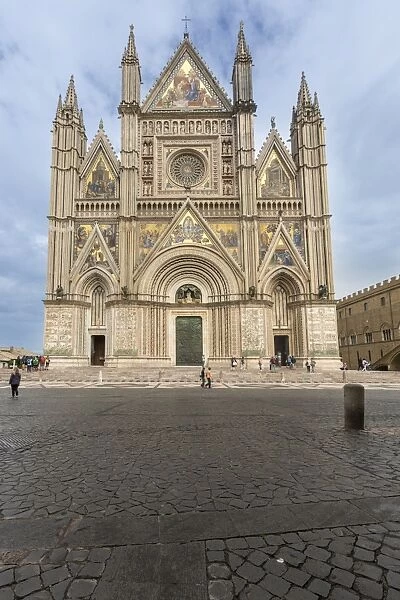 View of the facade of the Gothic cathedral with golden mosaics and bronze doors, Orvieto