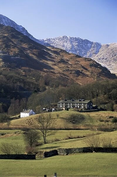 View across fields to cottages and snow-capped mountains, Little Langdale