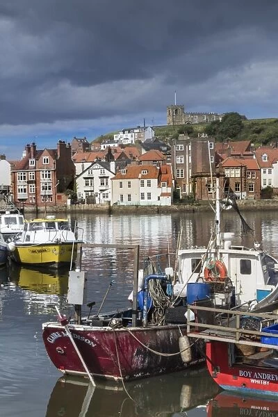 View of fishing boats in the harbour and the town centre, Whitby, Yorkshire, England