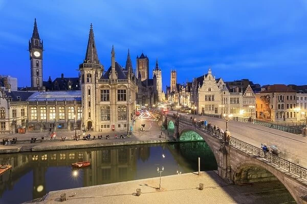 View of the historic area of Graslei and bell tower along Leie river at dusk, Ghent