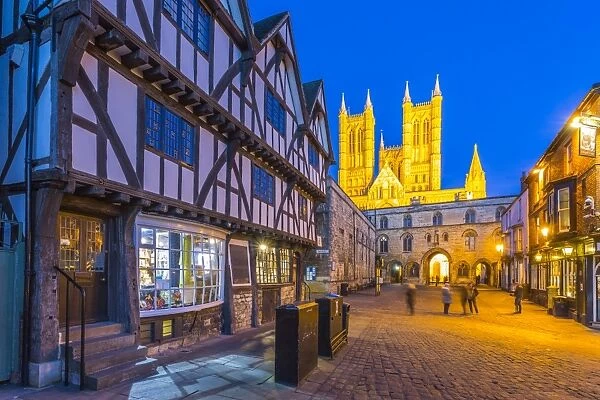 View of illuminated Lincoln Cathedral viewed from Exchequer Gate with timbered architecture