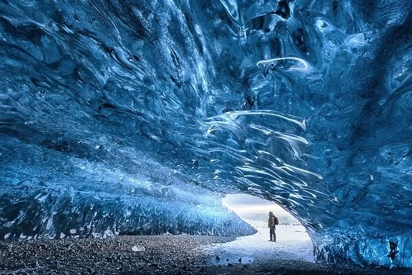 View from inside ice cave under the Vatnajokull Glacier with person for scale, near