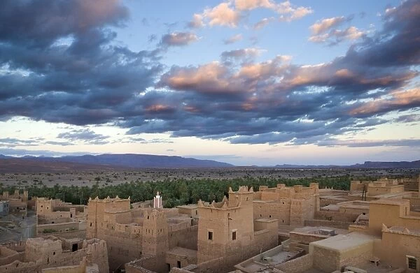 View over kasbahs (fortified houses) to flat desert plains and Jbel Sarhro Mountains