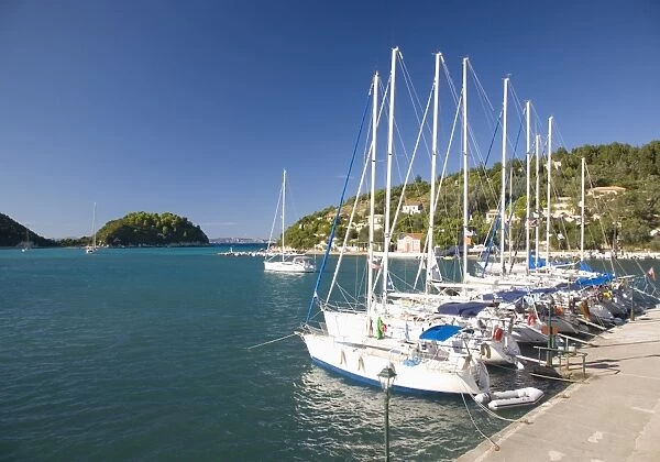View across Lakka Bay, yachts lined up along the quay, Lakka, Paxos, Paxi, Corfu, Ionian Islands, Greek Islands, Greece, Europe