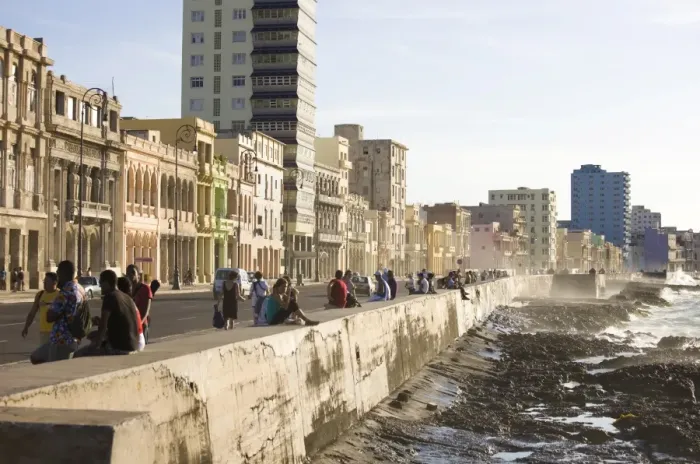 Framed Print : View along The Malecon showing people sitting on the seawall enjoying the evening sunshine