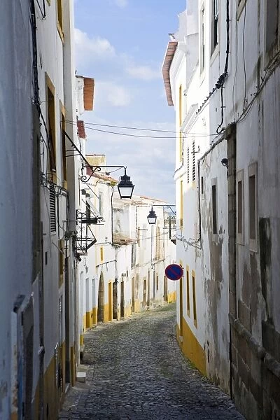 View along the medieval cobbled street of Rua do Moeda in historic centre of Evora