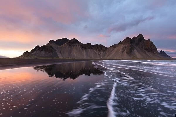 View of the mountains of Vestrahorn from black volcanic sand beach at sunset, Stokksnes