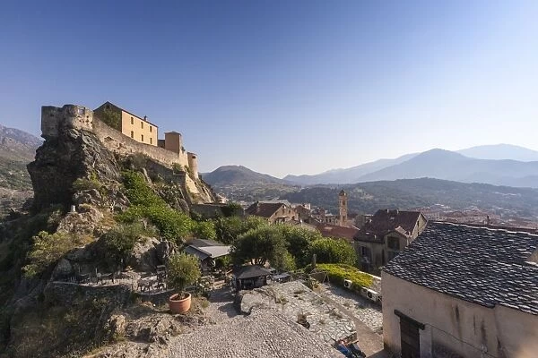 View of the old town of citadel of Corte perched on the hill surrounded by mountains