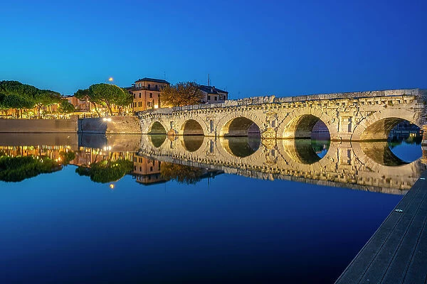 View of Ponte di Tiberio reflecting in Rimini Canal in Borgo San Giuliano district at dusk, Rimini, Emilia-Romagna, Italy, Europe